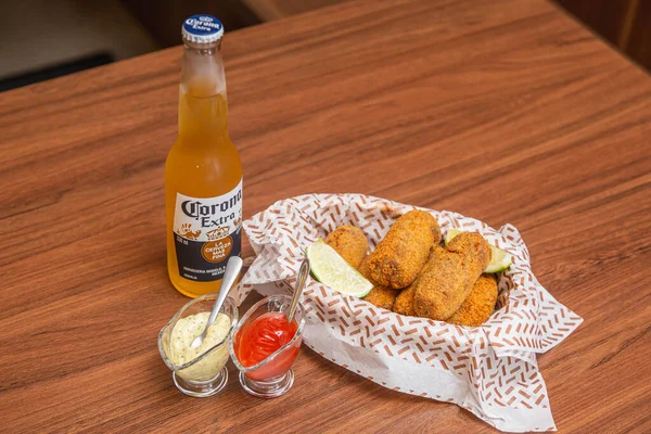 鸡肉小吃 典型的巴西小吃 配上柠檬片 辣椒酱和蛋黄酱 在木制桌子上放着著名的科罗那啤酒 — 图库照片