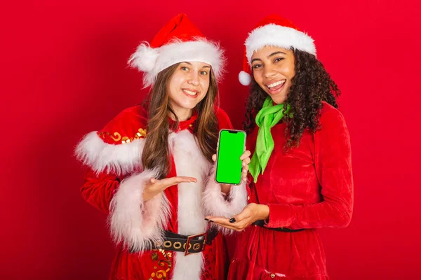 巴西的女性朋友 穿着圣诞服装 圣诞老人 用彩色显示智能手机屏幕 — 图库照片