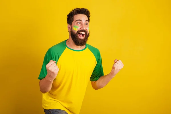 ブラジル出身の髭とブラジル人サッカーファンを持つ白人男性がお祝いしますうわぁ — ストック写真