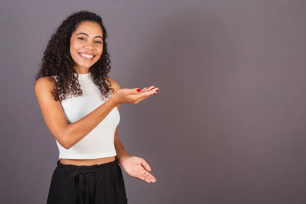 年轻的巴西黑人妇女向右展示她的双手 宣传照片 — 图库照片