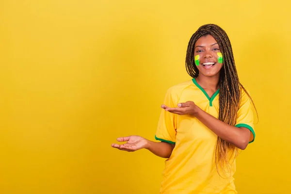 Czarna Kobieta Młoda Brazylijska Fanka Piłki Nożnej Prezentując Coś Lewej — Zdjęcie stockowe