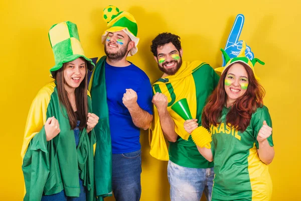 ブラジル出身の友人やサッカーファンがブラジルの旗を使いゴールを叫び笑顔でパーティーをします — ストック写真