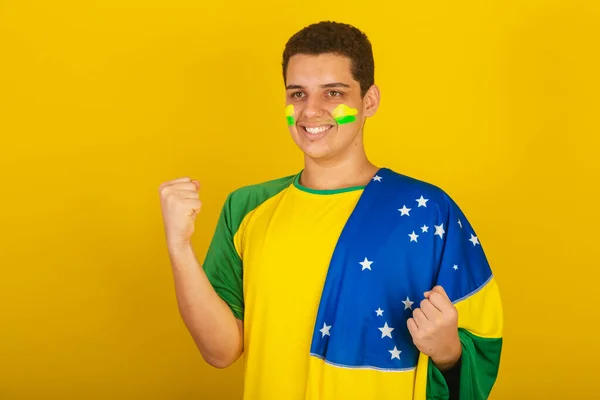 若いブラジル人のサッカーファン 胸に手をかけて緑の服を着てブラジルの国旗を祝い — ストック写真