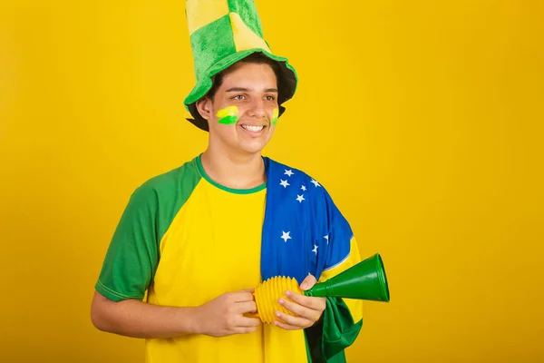 若いブラジル人のサッカーファン 緑の服を着て角を握りブラジルの国旗を胸に — ストック写真