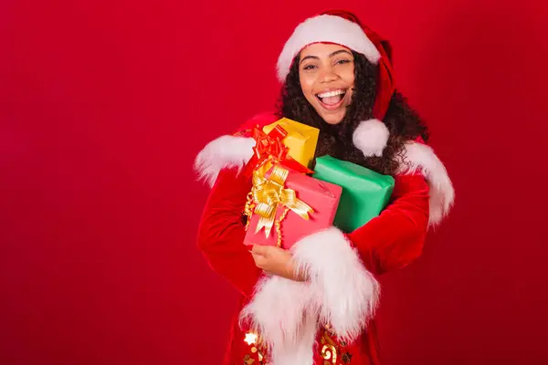 美丽的巴西黑人女人 穿着圣塔克洛斯的衣服 圣诞服装 持有三份礼物 — 图库照片