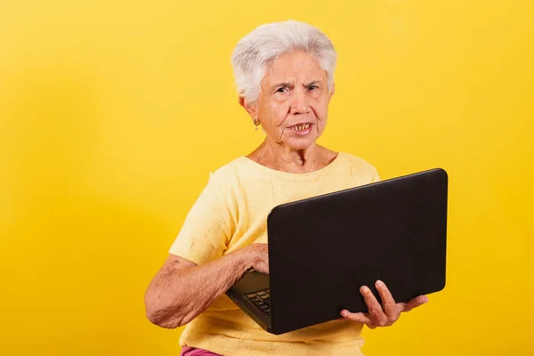 Old lady holding notebook, laptop. inclusion of the elderly in the digital environment.