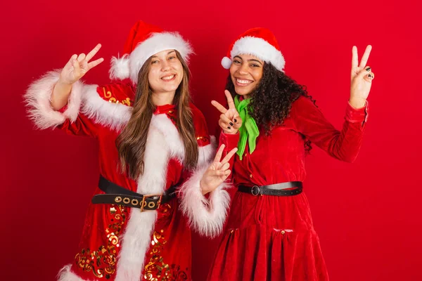 Δύο Βραζιλιάνες Φίλες Ντυμένες Χριστουγεννιάτικα Ρούχα Σήμα Ειρήνης Και Αγάπης — Φωτογραφία Αρχείου