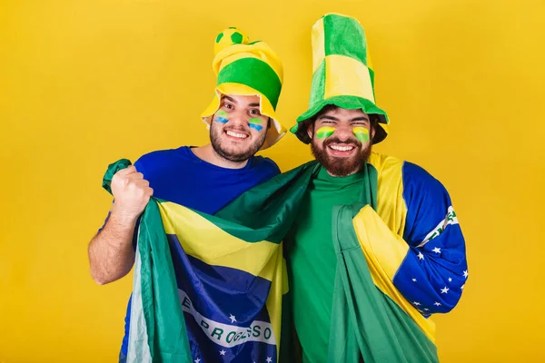 two friends, Brazilians, soccer fans from Brazil, cheering, celebrating and vibrating in a soccer match.