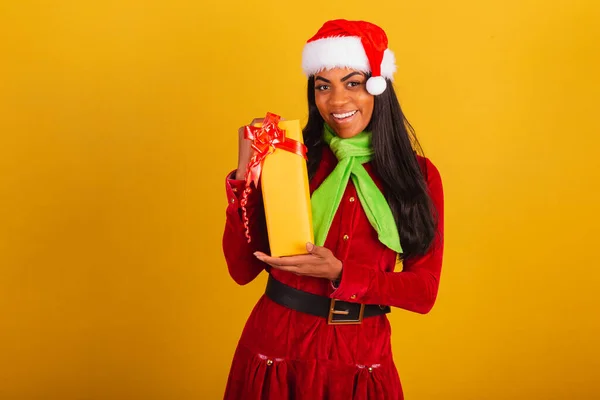 美しい黒ブラジルの女性 クリスマス服を着て サンタクラス 黄色の贈り物を保持 — ストック写真