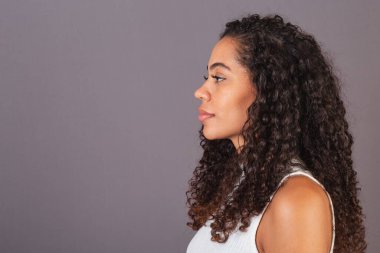 Sola bakan siyah Brezilyalı genç bir kadın. Resmi kapat.