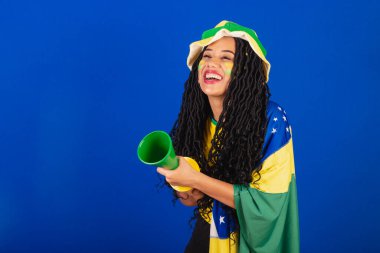 Genç siyah Brezilyalı kadın, futbol fanatiği. Korna sesi çıkararak..