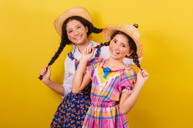 Festa Junina 'nın tipik kıyafetlerini giyiyorlar. Saç tutmak ve gülümsemek, komik bir fotoğraf. Eğlenceli..
