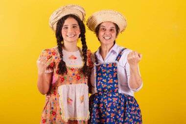 Büyükanne ve torun tipik Festa Junina kıyafetleri giymişler. Ellerinle çağır, davet et, buraya gel..