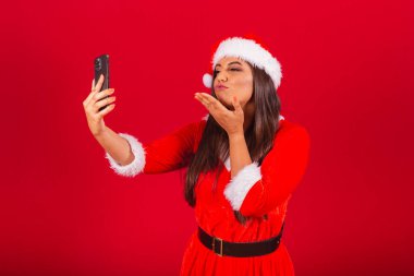 Noel kıyafetleri giymiş güzel Brezilyalı kadın, Noel Baba. Akıllı telefon video araması tutuluyor.
