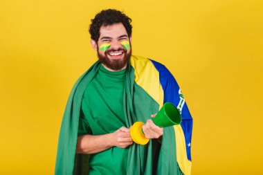 Brezilyalı, sakallı, Brezilyalı futbol fanatiği, dünya kupası maçında boynuzunu kullanıyor, parti yapıyor, gürültü yapıyor..