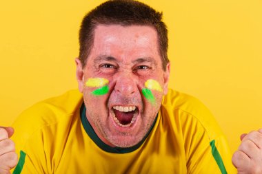 Yetişkin adam Brezilya futbolu fanatiği bağırma golünü, yakın çekim fotoğrafını kutluyor