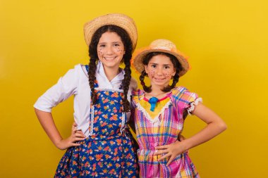 Festa Junina için tipik kıyafetler giyiyorlar. Elleri kalçalarında sarıldılar. Arraia partisi için.