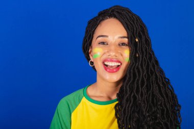 Genç siyah Brezilyalı kadın, futbol fanatiği. Gülümseyen dişlerin yakın plan fotoğrafı..