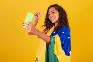 Genç siyah Brezilyalı, futbol taraftarı. Selfie ve akıllı telefondan kendi portresini yapıyor..