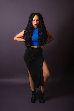 Güzel siyah Brezilyalı kadın, mavi giyinmiş. Tam boy portre, gri sonsuz arkaplan.