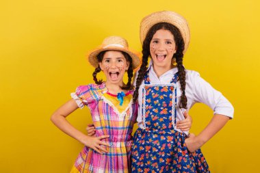 Festa Junina için tipik kıyafetler giyiyorlar. Elleri kalçasında sarılmış, inanılmaz bir ifade. Arraia partisi için.