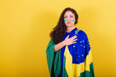 Kadın futbol fanatiği, Brezilya taraftarı, Dünya Kupası, milli marşı söyleyen. Eller göğüste..