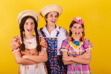 Büyükannesi ve iki torunu tipik Festa Junina kıyafetleri giymişler. Şaşırmış, şaşırmış, vay canına, inanılmaz.