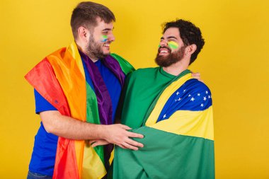 Brezilya 'lı bir çift erkek, futbol taraftarı, LGBT bayrağı takıyor.