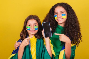 Brezilya 'dan kız kardeşler ve arkadaşlar, futbol hayranları, cep telefonuna, internete, bağlı dünyaya, cep telefonu uygulamasına işaret ediyorlar. Dünya Kupası. Olimpiyatlar.