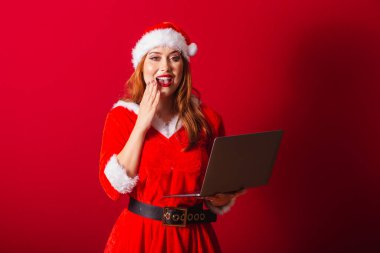 Güzel Brezilyalı kızıl saçlı kadın, Noel kıyafetleri giymiş, Noel Baba. Not defterini tutuyorum. İnanılmaz, inanılmaz..
