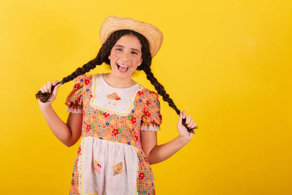 Dziewczyna Nosi Tradycyjne Pomarańczowe Ubrania Festa Junina Trzymając Warkocze Uśmiechając — Zdjęcie stockowe