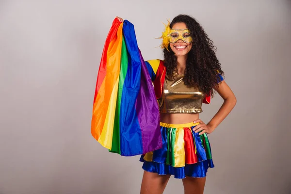 stock image Beautiful black Brazilian woman, with frevo clothes, carnival. wearing a mask, using the lgbt flag.