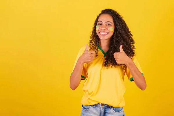 若い黒人のブラジル人女性サッカーファン サイン 親指アップ 肯定など — ストック写真