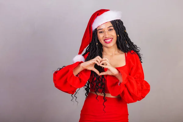 ブラジルの黒人女性クリスマス服を着て陽気なクリスマス笑顔ハートサイン — ストック写真