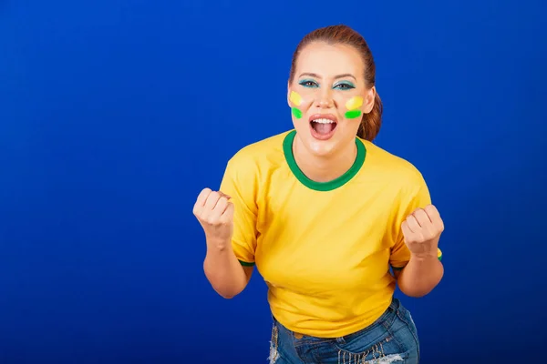 白人妇女 红头发 巴西足球迷 巴西人 蓝色背景 尖叫进球 — 图库照片