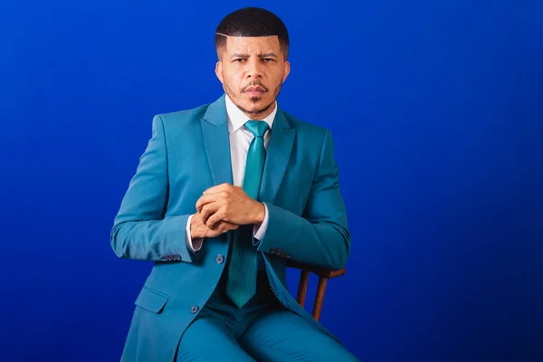 スーツと青いネクタイを着たブラジルの黒人男性 ビジネスマン 木製の椅子のポーズ — ストック写真
