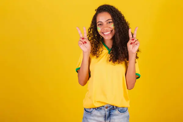 若い黒人のブラジル人女性サッカーファン 指で平和と愛のサイン 良い振動 — ストック写真