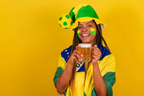 black woman young brazilian soccer fan. drinking beer and celebrating.