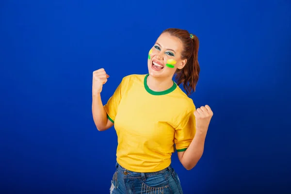 Kaukasierin Rotschopf Brasilianischer Fußballfan Brasilianerin Blauer Hintergrund Feiern Und Zwinkern — Stockfoto