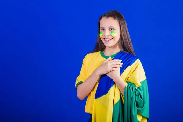 Stock image young girl, soccer fan from Brazil. dressed in flag, singing national anthem. Gratitude.