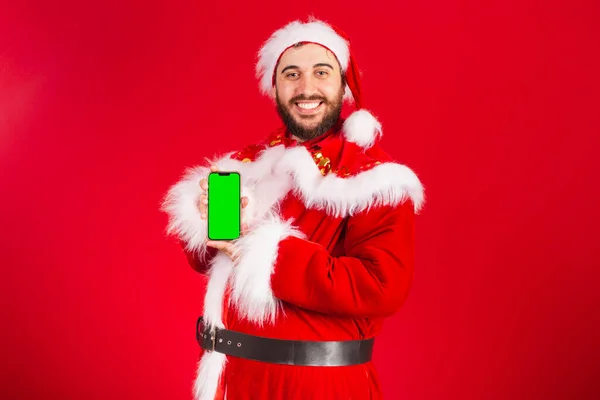 Brasiliansk Mann Kledd Santa Claus Som Holder Smarttelefon Med Grønn – stockfoto