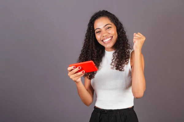 Genç Brezilyalı Siyahi Kadın Cep Telefonundan Bir Şey Izliyor Kutluyor — Stok fotoğraf