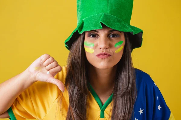 Close-up photo, Woman supporter of Brazil, world cup 2022, negative, denial, didn't like it. wearing cheerleading outfit, flag and hat.