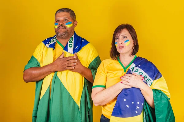 一对夫妇 红头发的女人和黑人男人 巴西足球迷 唱国歌 — 图库照片