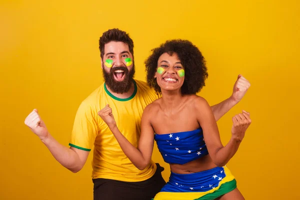 ブラジルのサッカーファンのカップルは ブラジルの色 黒の女性 白人男性に身を包んだ チームの幸運を祈る — ストック写真