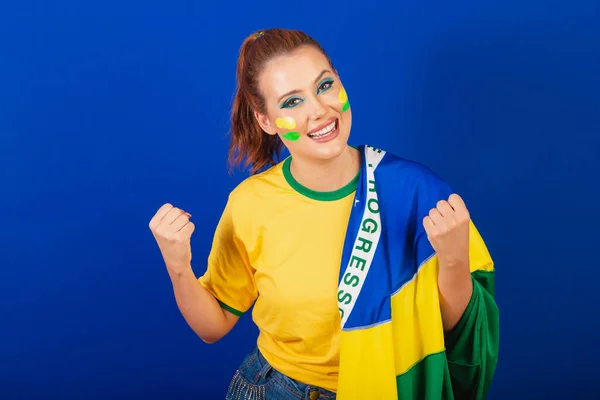 白人妇女 红头发 巴西球迷 巴西人 蓝色背景 身穿巴西国旗 — 图库照片