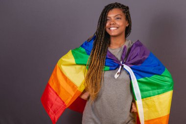 LGBT, LGBTQ, çeşitlilik ve cinsiyet eşitliği ve cinsellik bayrağı olarak bayrak taşıyan Afrikalı genç bir kadın..