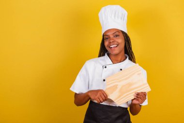 Genç afro Brezilyalı kadın, aşçı, gastronomi için ahşap tahta tutuyor..