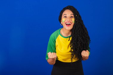 Genç siyah Brezilyalı kadın, futbol fanatiği. Kutlama ve kutlama.