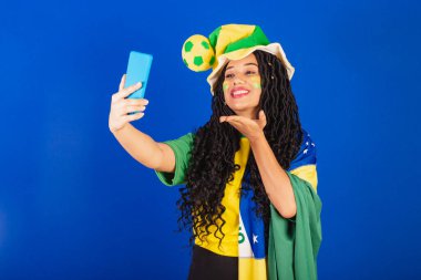 Genç siyah Brezilyalı, futbol taraftarı. Selfie ve akıllı telefondan kendi portresini yapıyor..